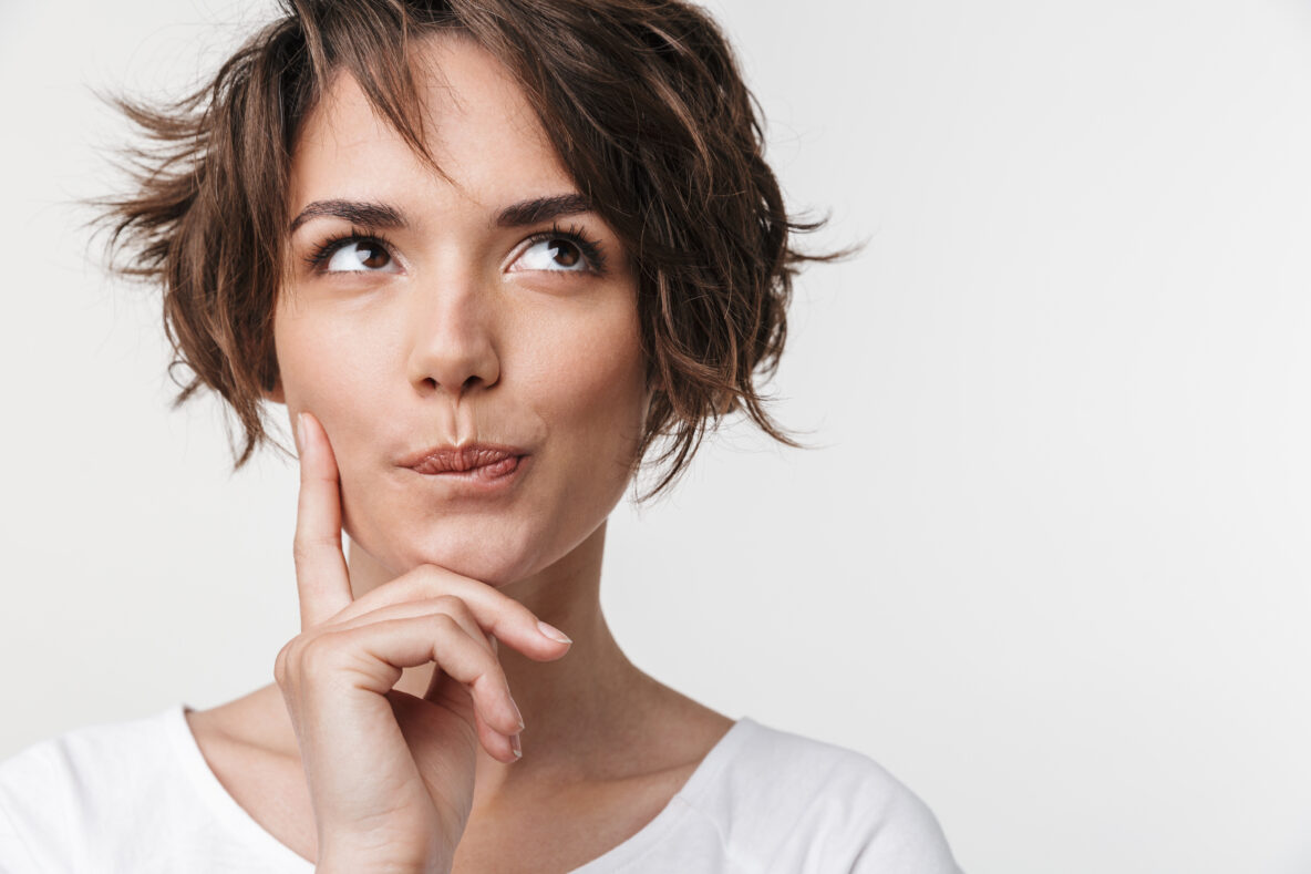 Beautiful young pretty thinking thoughtful woman posing isolated over white wall background.